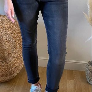 Jeans Enzo noir - Taille haute Coupe Slim - Passants pour la ceinture - Petit bijoux strass sur le revers du pantalon et sur la poche droite - 66% coton - 32,5% polyester - 1,5% élasthanne